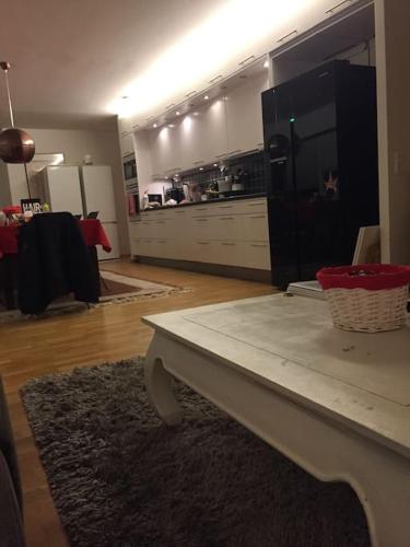 a living room with a table and a kitchen at Eurovision city apartment malmö in Malmö