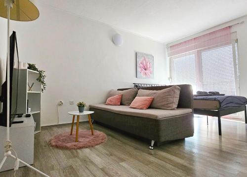 a living room with a couch and a table at Studio apartman IN Self check in in Osijek
