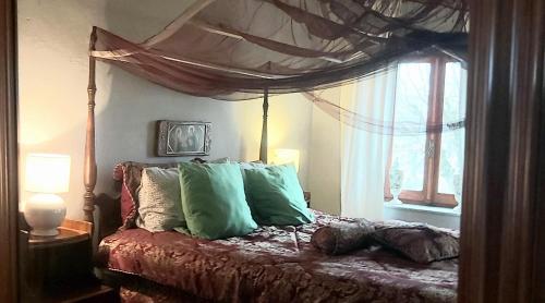 - une chambre avec un lit doté d'oreillers verts et d'une fenêtre dans l'établissement Rana Cantante, à Mombercelli