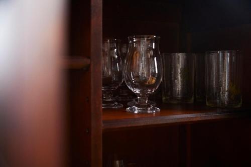a row of wine glasses sitting on a shelf at Lhotel de Mai in Tamba-sasayama