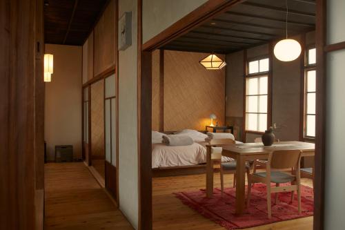 Tamba-sasayamaにあるLhotel de Maiのベッド、テーブル、ダイニングルームが備わります。