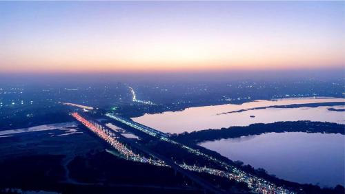 uma vista aérea de uma ponte sobre uma massa de água em Tranquil river heaven ! em Noida