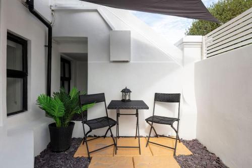 une terrasse avec deux chaises et une table avec une plante dans l'établissement Luxury 1 bed apartment - Wanstead Village, à Londres