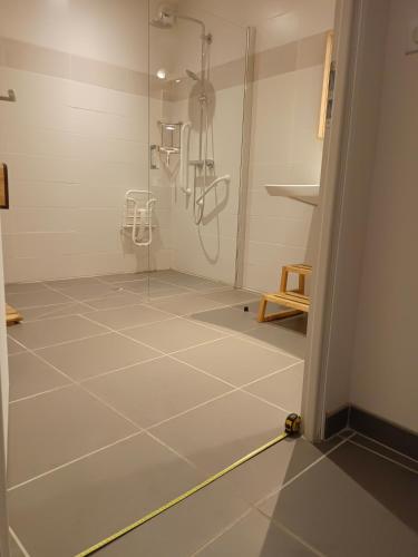 La salle de bains est pourvue d'une douche et de carrelage. dans l'établissement Le Jardin de l'Albert, à Beurey-Bauguay