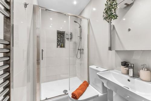 a white bathroom with a shower and a sink at Few remaining days available for May - book now in Bristol