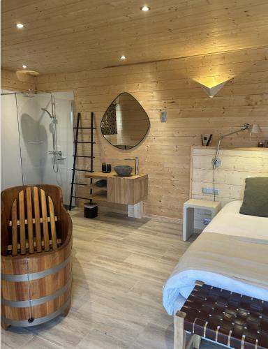 une chambre avec un lit, un miroir et une chaise dans l'établissement Les Lodges de Malbrough, à Aire-sur-la-Lys