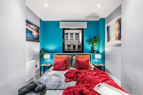 1 dormitorio con paredes azules y 1 cama con almohadas rojas en Few remaining days available for May - book now, en Bristol