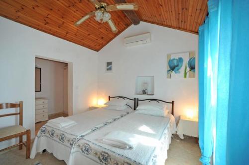 a bedroom with a bed and a ceiling fan at Nikatsas Cottage No 1 in (( Kerasá ))