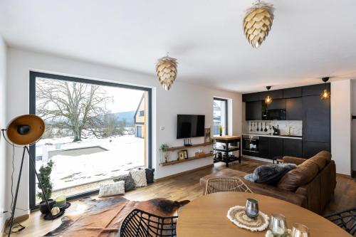a living room with a couch and a table at Panorama Chlum Resort - Apartmán 2kk, 701 in Volary