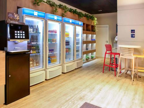 a store with refrigerators and red chairs in a room at ibis budget Maceió Pajuçara in Maceió