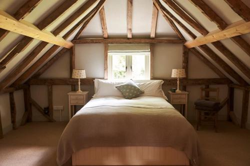ein Schlafzimmer mit einem großen Bett im Dachgeschoss in der Unterkunft Stride’s Barn in Whiteparish