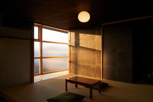 a room with a table and a large window at Lhotel de Mai in Tamba-sasayama