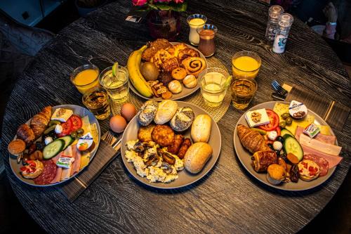 Una mesa con muchos platos de comida encima. en Grand Hotel Downtown, en Ámsterdam