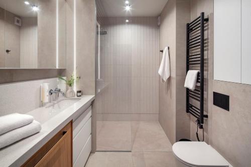 a bathroom with a shower and a toilet and a sink at Apartamenty na Półwyspie Wydma&Las in Jastarnia