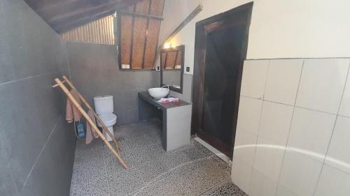3 Angels One-Bedroom Villa في غيلي آير: حمام فيه مغسلة ومرحاض