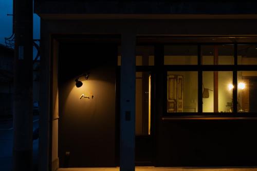 a door with a clock on the side of a building at Lhotel de Mai in Tamba-sasayama