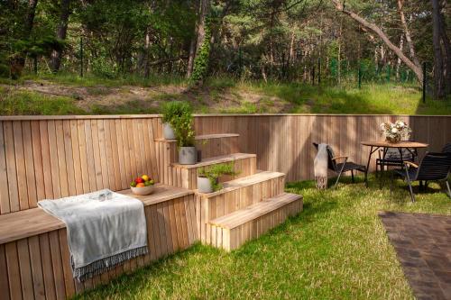 a backyard with a table and chairs and a fence at Apartamenty na Półwyspie Wydma&Las in Jastarnia