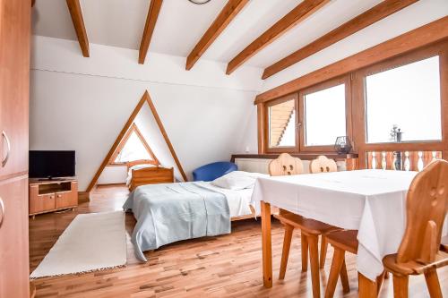 a room with a dining table and two beds at Willa Pod Orłem Jacuzzi Sauna in Kościelisko