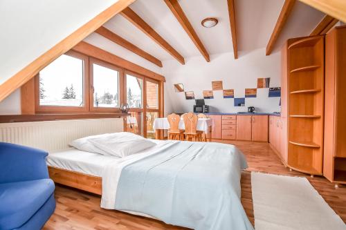 a bedroom with a bed and a table and chairs at Willa Pod Orłem Jacuzzi Sauna in Kościelisko
