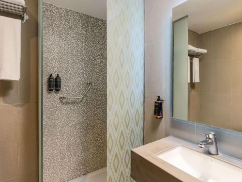 a bathroom with a sink and a shower at Mercure Makkah Aziziah in Makkah