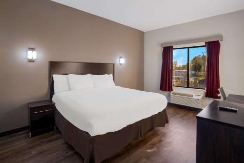1 cama blanca grande en una habitación de hotel con ventana en Rodeway Inn, en Brandon