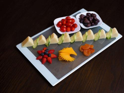 a plate of fruit and vegetables on a table at Mercure Makkah Aziziah in Makkah