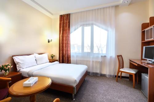 a hotel room with a bed and a window at Alpina Resort by Stellar Hotels, Tsaghkadzor in Tsaghkadzor