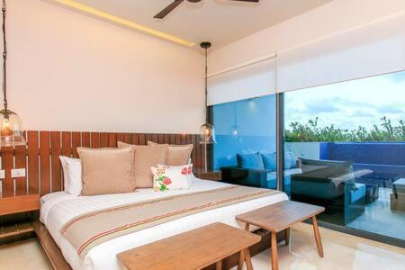 1 dormitorio con 1 cama grande y balcón en Gorgeous Private Pool with Terrace Steps to Beach and 5th Ave!, en Playa del Carmen