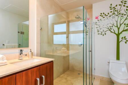 uma casa de banho com um chuveiro, um lavatório e um WC. em Gorgeous Private Pool with Terrace Steps to Beach and 5th Ave! em Playa del Carmen