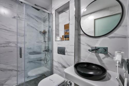 a bathroom with a shower and a toilet and a mirror at Joyway Hotels Istanbul Sultanahmet in Istanbul