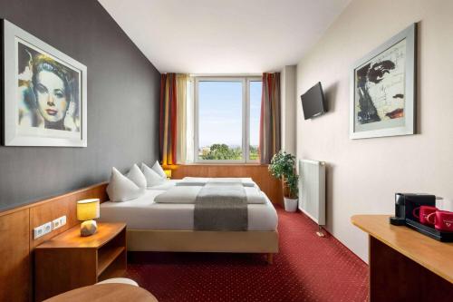 a hotel room with a bed and a window at Amedia Express Passau, Trademark Collection by Wyndham in Passau