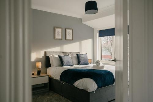 a bedroom with a large bed and a window at Canterbury House By Horizon Stays in Redcar