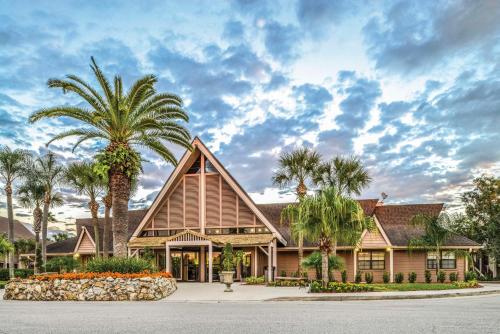 a house with palm trees in front of it at Hilton Vacation Club Polynesian Isles Kissimmee in Kissimmee