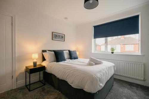 a bedroom with a large bed with a window at Canterbury House By Horizon Stays in Redcar
