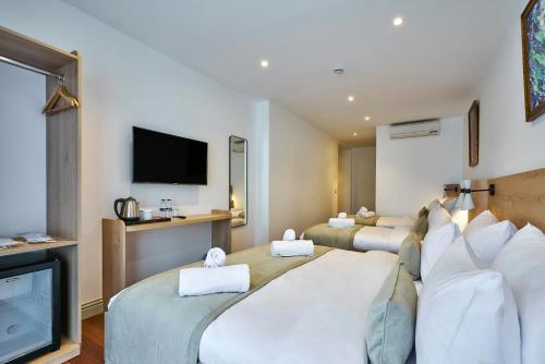 a hotel room with three beds and a flat screen tv at Joyway Hotels Istanbul Sultanahmet in Istanbul