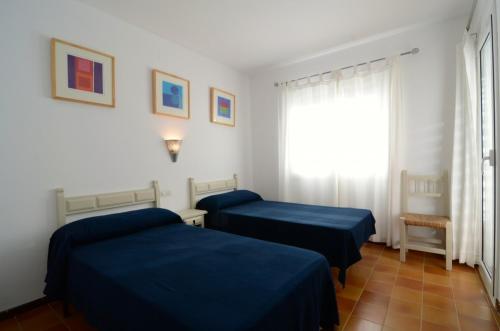 Habitación con 2 camas y ventana en Apartamento Mar Blau II, en Begur