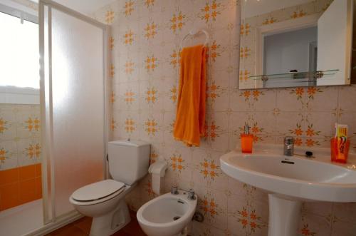 y baño con aseo y lavamanos. en Apartamento Mar Blau II, en Begur