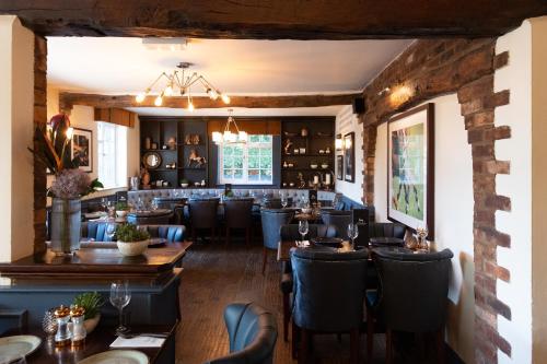 a restaurant with tables and chairs and a bar at The Dog in Over Peover in Knutsford