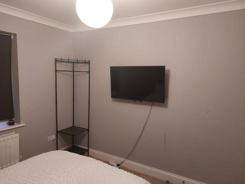 1 dormitorio con TV de pantalla plana en la pared en Short Stay at Dartford!!!, en Dartford
