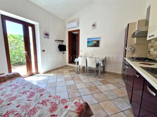 Habitación blanca con cocina y mesa en Villetta Fantasia a 100 m dalla spiaggia, en Vignola Mare