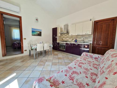 a living room with a couch and a kitchen at Villetta Fantasia a 100 m dalla spiaggia in Vignola Mare