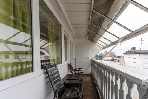 2 stoelen op een balkon met ramen bij Monteurapartment 7 in Rodgau