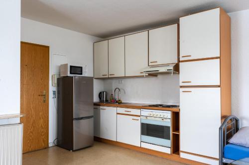 een keuken met witte kasten en een koelkast bij Monteurapartment 7 in Rodgau