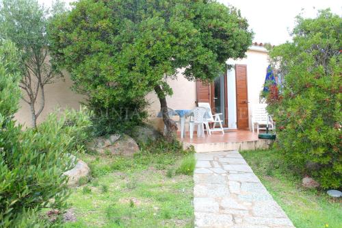 a house with a table and chairs on a porch at Villetta Fantasia a 100 m dalla spiaggia in Vignola Mare