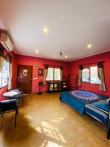 a bedroom with red walls and a bed and a table at Mandala bungalow at Ya Nui beach in Rawai Beach