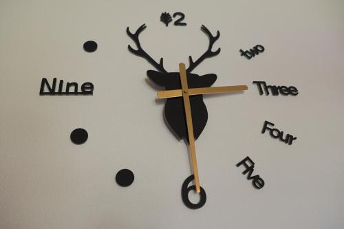um relógio com uma rena na parede em Croisée A em Lens