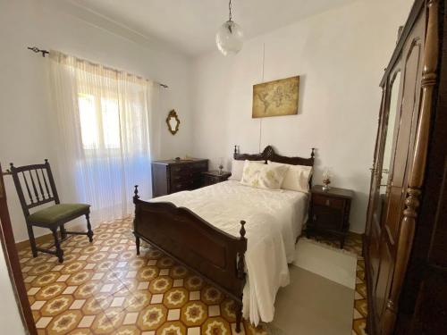un dormitorio con una cama y una silla en Casa Ti Barbara, en Cachopo