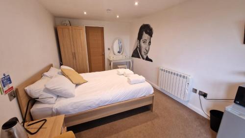 a bedroom with a bed with a picture of a man at Relaxing Room With Ensuite Rutland Point in Oakham