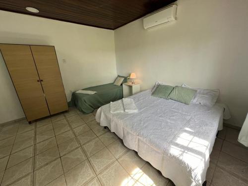 a bedroom with a bed and a cabinet in it at Pousada Recanto da Palmeira in Guaíba
