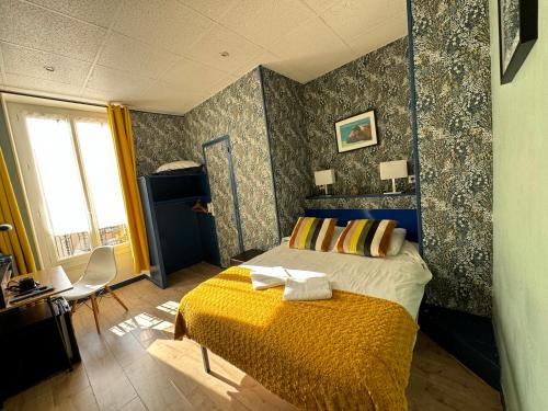 a bedroom with a bed with a yellow blanket at Hotel des Dames in Nice